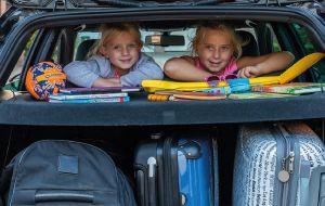 kinderen op achterbank van auto gaan op vakantie met een doorlopende reisverzekering