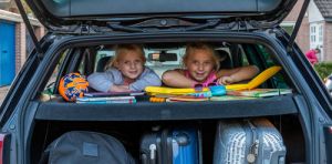 kinderen op achterbank auto klaar om op vakantie te gaan