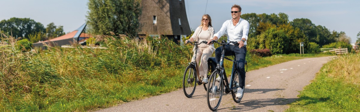 twee nh1816 verzekerden met fietsverzekering nabij een molen