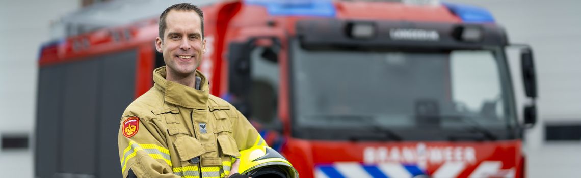 brandweerman staat voor brandweerauto