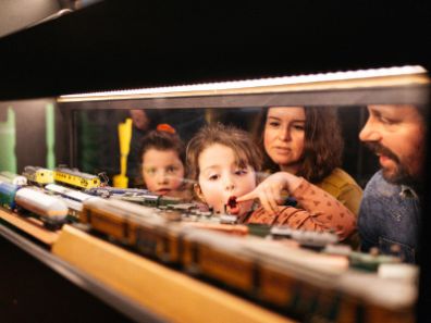 kinderen wijzen naar modeltreinen in spoorwegmuseum