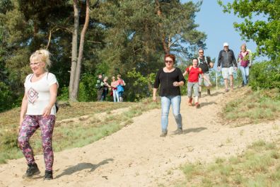 personen lopen in duinen tijdens Wandele naor Schandele