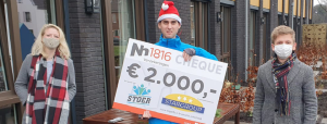 persoon met kerstmuts met cheque van € 2.000 in de hand