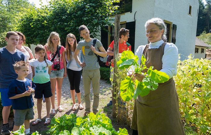 vrouw in moestuin geeft demo in het Openluchtmuseum