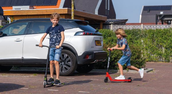 kinderen op step in nieuwbouwwijk met aansprakelijkheidsverzekering