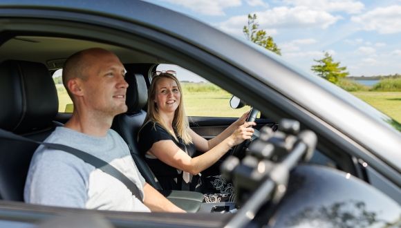 man en vrouw zitten verzekerd in auto