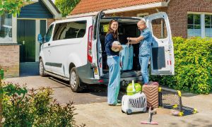 stel pakt bestelauto in met reiskoffer en andere vakantie attributen