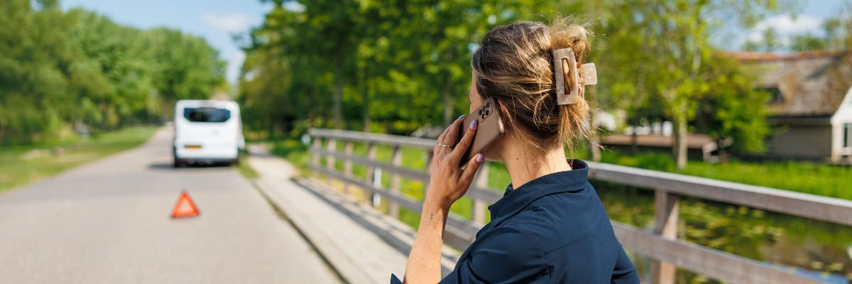 Vrouw met pech langs de weg op brug