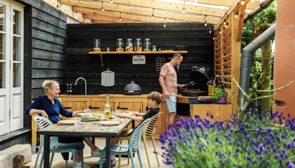 gezin aan het barbecuen in veranda