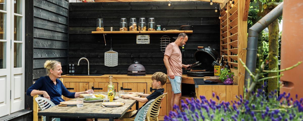 gezin aan het barbecuen in veranda