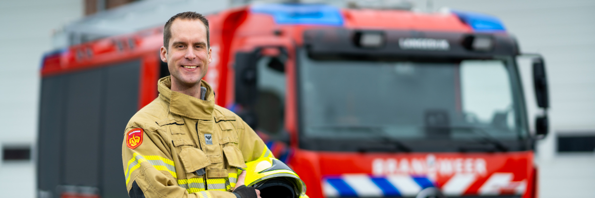 brandweer Jeroen Egbers staat vooor zijn brandweer auto